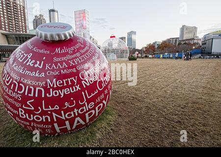 Riesige rote Weihnachtsschmuck mit Frohe Weihnachten in mehreren geschrieben Sprachen sitzt auf dem Rasen bei World of Coke in der Nähe Centennial Park in Atlanta Stockfoto