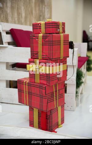 Geschenkschachteln am weihnachtsbaum. Frohes neues Jahr. Feiern Sie Weihnachten zu Hause. Winterurlaubseinkäufe. Einkaufsverkauf. Geschenklieferung. Rot, Rosa, Silber Stockfoto