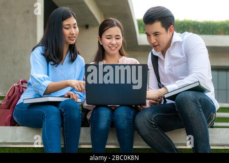 Drei asiatische Studenten diskutieren über Prüfungsvorbereitung, Präsentation, Studium, Studie zur Testvorbereitung mit Laptop an der Universität. Bildung, Lear Stockfoto