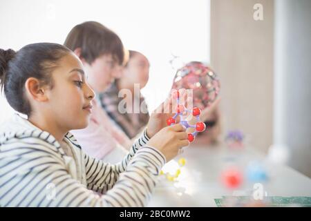 Neugieriges Mädchen untersucht Molekularmodell im Klassenzimmer Stockfoto