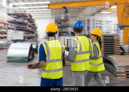 Arbeiter gehen und sprechen in Fabrik Stockfoto