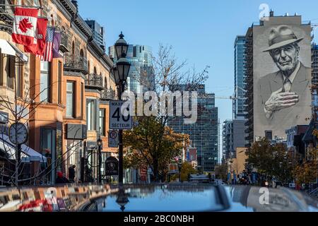 KANADISCHE FLAGGE UND WANDBILD VON LEONARDS COHEN IN EINEM GEBÄUDE, RUE CRESCENT, MONTREAL, QUEBEC, KANADA Stockfoto