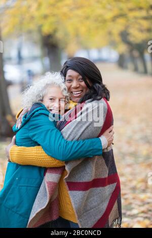 Begeisterte Senioren-Freunde umarmen sich im Herbstpark Stockfoto