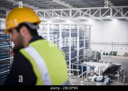 Gespräch mit einem männlichen Vorgesetzten, Verwendung von Walkie-Talkie auf der Plattform im Werk Stockfoto