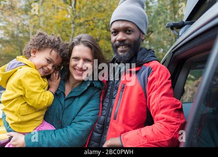 Portrait fröhliche multiethnische Familie, die vor dem Auto steht Stockfoto