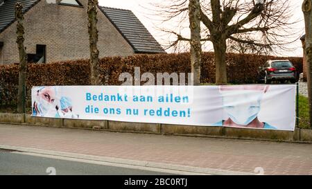 Aaigem, Belgien, 29. März 2020: Banner mit dem Image des medizinischen Personals und vielen Dank an alle, die uns jetzt während der Coronakrise retten. Ländlicher Raum. Auf Niederländisch: Bedankt aan allen die ons nu redden. Stockfoto