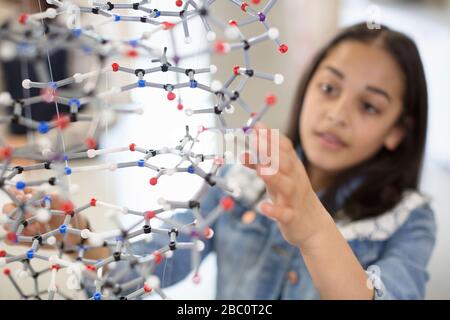 Mädchen Student untersucht und berührt Molekularstruktur im Klassenzimmer Stockfoto