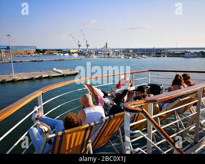 Passagiere einer Fähre auf Liegestühlen entspannen und in Urlaub fahren. Stockfoto