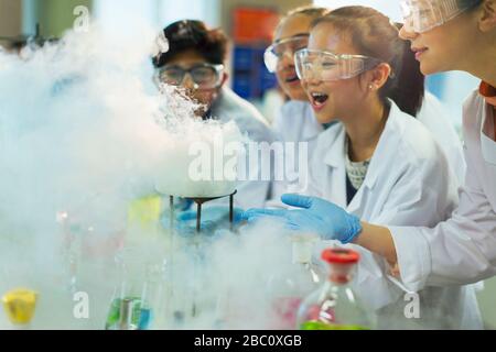 Überraschte, neugierige Studenten beobachten chemische Reaktionen und führen wissenschaftliche Experimente im Laborunterricht durch Stockfoto
