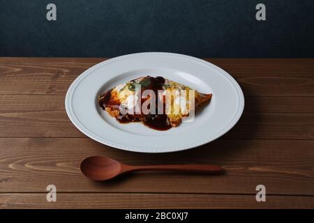 Omuraisu omu Reis Omelett japanisches Essen auf dem Teller auf dem Tisch isoliert Stockfoto