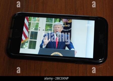 Auf einem Smartphone betrachtet, spricht Präsident Donald Trump, da Mitglieder der Coronavirus Task Force eine Presse halten Stockfoto