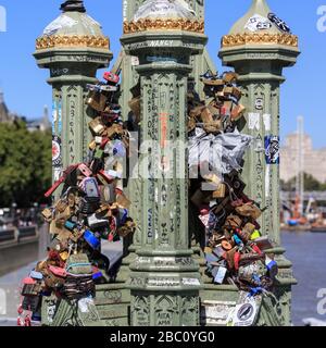 Liebesschlösser, Schlösser mit den Initialen der Liebhaber und Liebesnachrichten, die an Geländern an der Westminster Bridge, London, Großbritannien angebracht sind Stockfoto