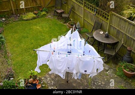 Weiße Herren Hemden hängen an einer rotierenden Wäscheleine während im Wind im Garten UK Stockfoto