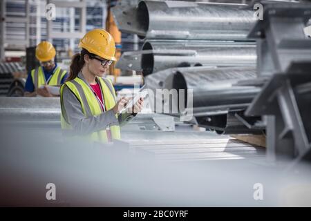 Weibliche Führungskraft, die digitale Tablette in der Stahlfabrik verwendet Stockfoto