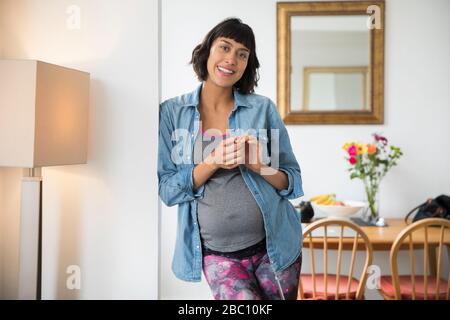 Portrait lächelnde schwangere Frau im Speisesaal Stockfoto