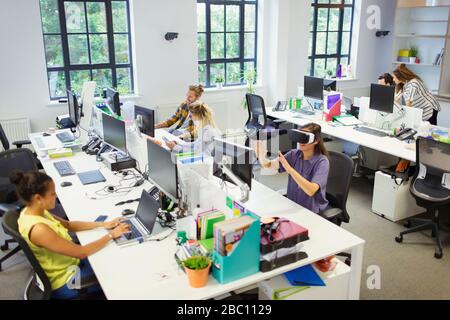 Designer und Computerprogrammierer, die in einem offenen Planbüro arbeiten Stockfoto