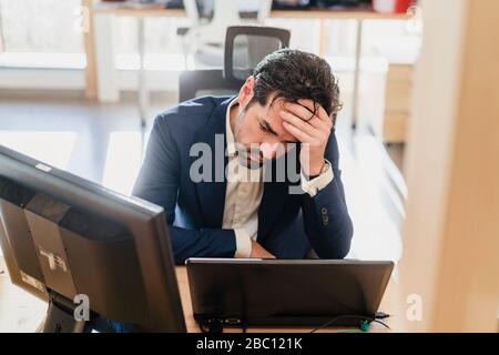 Frustriert Geschäftsmann am Schreibtisch im Büro Stockfoto