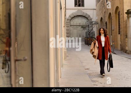 Frau, die in einer Gasse in der Stadt, Florenz, Italien Stockfoto