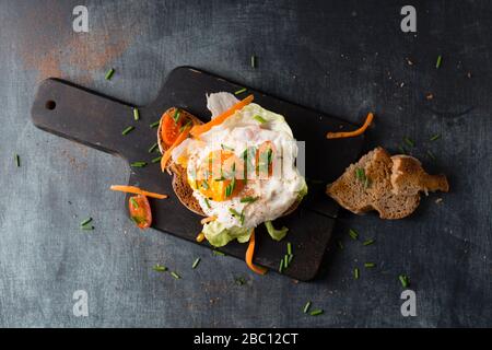 Spiegelei mit Brot und Gemüse auf dem Schneidebrett Stockfoto