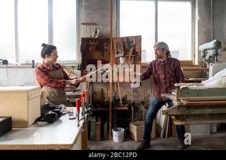 Spielerische Handwerker und Handwerker kämpfen in ihrer Werkstatt Stockfoto