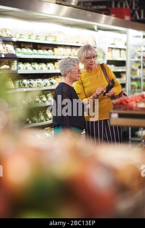 Seniorinnen mit Smart-Phone-Lebensmittelgeschäft im Supermarkt Stockfoto