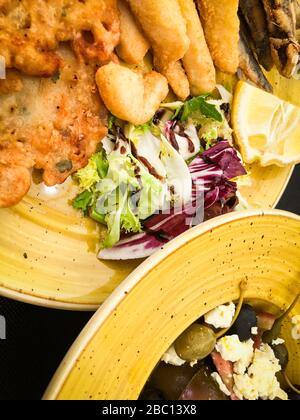 Mischen Sie frittierte Fische und Meeresfrüchte mit frischem Salat und Zitronensaft Stockfoto