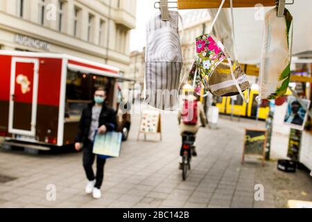 Berlin, Deutschland. April 2020. Mund- und Nasenmasken hängen an einem Verkaufsstand am Hackeschen Markt. Immer mehr Menschen nähen ihren eigenen Mund- und Nasenschutz. Credit: Carsten Koall / dpa / Alamy Live News Stockfoto