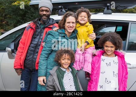 Portrait Happy Family außerhalb des Autos auf dem Parkplatz Stockfoto