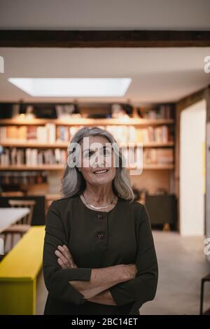 Porträt einer lächelnden grauen Geschäftsfrau in einem Loft-Büro Stockfoto
