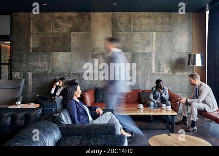 Geschäftsleute, die in der Hotellobby eine Tagung abhalten Stockfoto