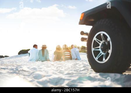 Junge Freunde entspannend, am Strand hinter Jeep hängen Stockfoto