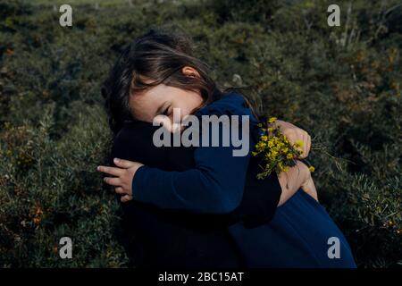 Mutter und kleine Tochter umarmen sich in der Natur Stockfoto