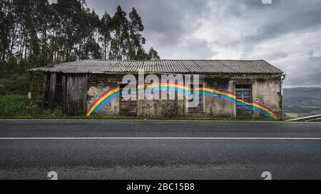 Spanien, Provinz A Coruna, San Saturnino, Regenbogen auf verlassenen Haus am Straßenrand gemalt Stockfoto