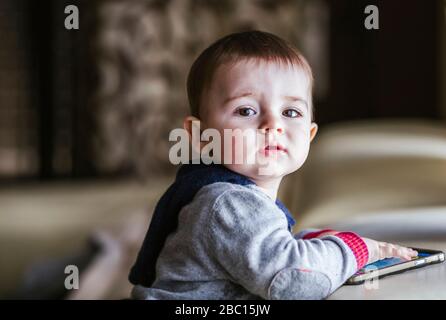 Porträt des Jungen spielt mit Smartphone Stockfoto