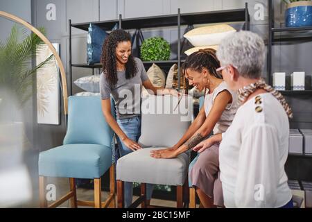 Frauen kaufen im hauseigenen Dekor-Shop nach Essstühlen Stockfoto