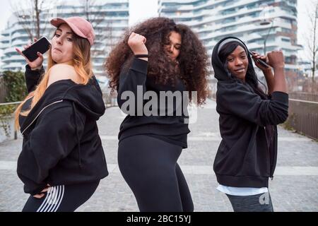 Drei sportliche junge Frauen tanzen in der Stadt Stockfoto