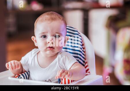 Porträt des kleinen Jungen im Hochstuhl sitzen Stockfoto