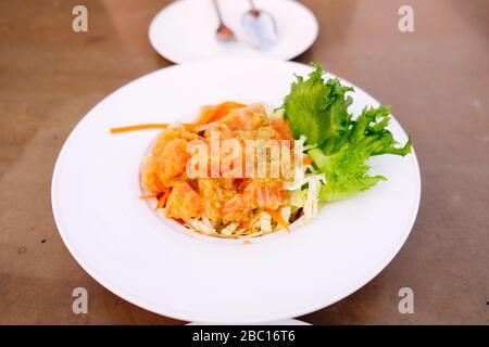 Lachswürziger Salat im thailändischen Stil auf dem weißen Gericht Stockfoto