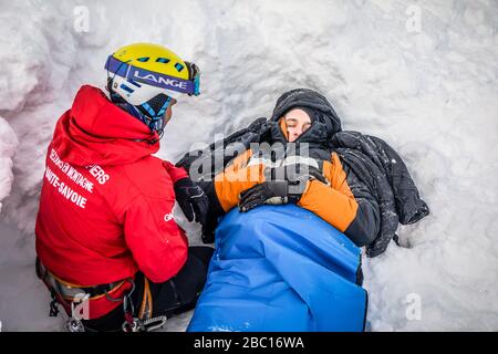 BEHANDLUNG EINES LAWINENOPFERS, FEUERWEHRLEUTE NATIONALE EXECISE BEI LAWINENRETTUNG, COL DU LAUTARET, HAUTES ALPEN (05) Stockfoto