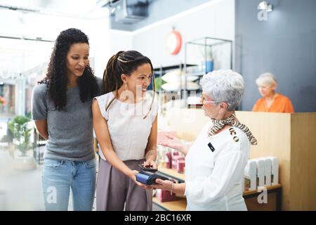 Frauen zahlen Kasse im Innendekor Stockfoto