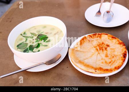 Grünes Curry-Huhn mit Roti auf weißem Gericht Stockfoto