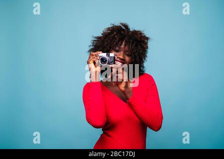 Porträt der glücklichen jungen Frau mit Vintage-Kamera im Studio Stockfoto