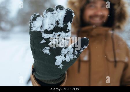 Grüner Handschuh mit Schnee, Nahaufnahme Stockfoto