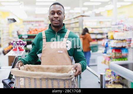 Portrait selbstbewusster männlicher Lebensmittelhändler, der im Supermarkt arbeitet Stockfoto