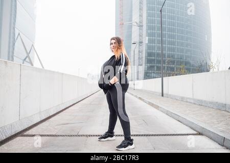 Plus size Sportive junge Frau posiert in der Stadt Stockfoto