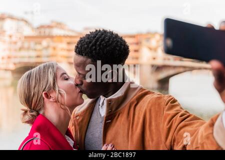 Liebevolles junges Paar küsst und macht ein Selfie in der Stadt Florenz, Italien Stockfoto