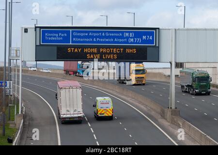 Glasgow, Schottland, Großbritannien. April 2020. Essential Vehicles Passing Under 'Stay Home Protect NHS Save Lives' - Zeichen in Glasgow Credit: Kay Roxby/Alamy Live News Stockfoto