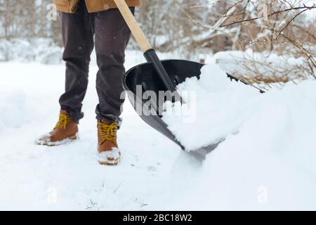 Ernteansicht von Mann schaufelt Schnee Stockfoto