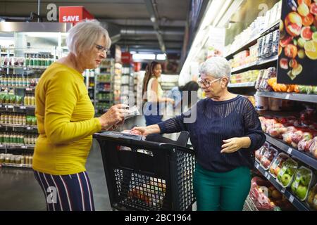 Seniorinnen Lebensmittelgeschäfte im Supermarkt Stockfoto