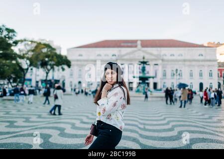 Junge Reisende, die eine Barette trägt und am Rossio Platz, Lissabon, Portugal posiert Stockfoto